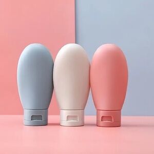 Set of Three Travel Bottles in Blue, cream, and Pink